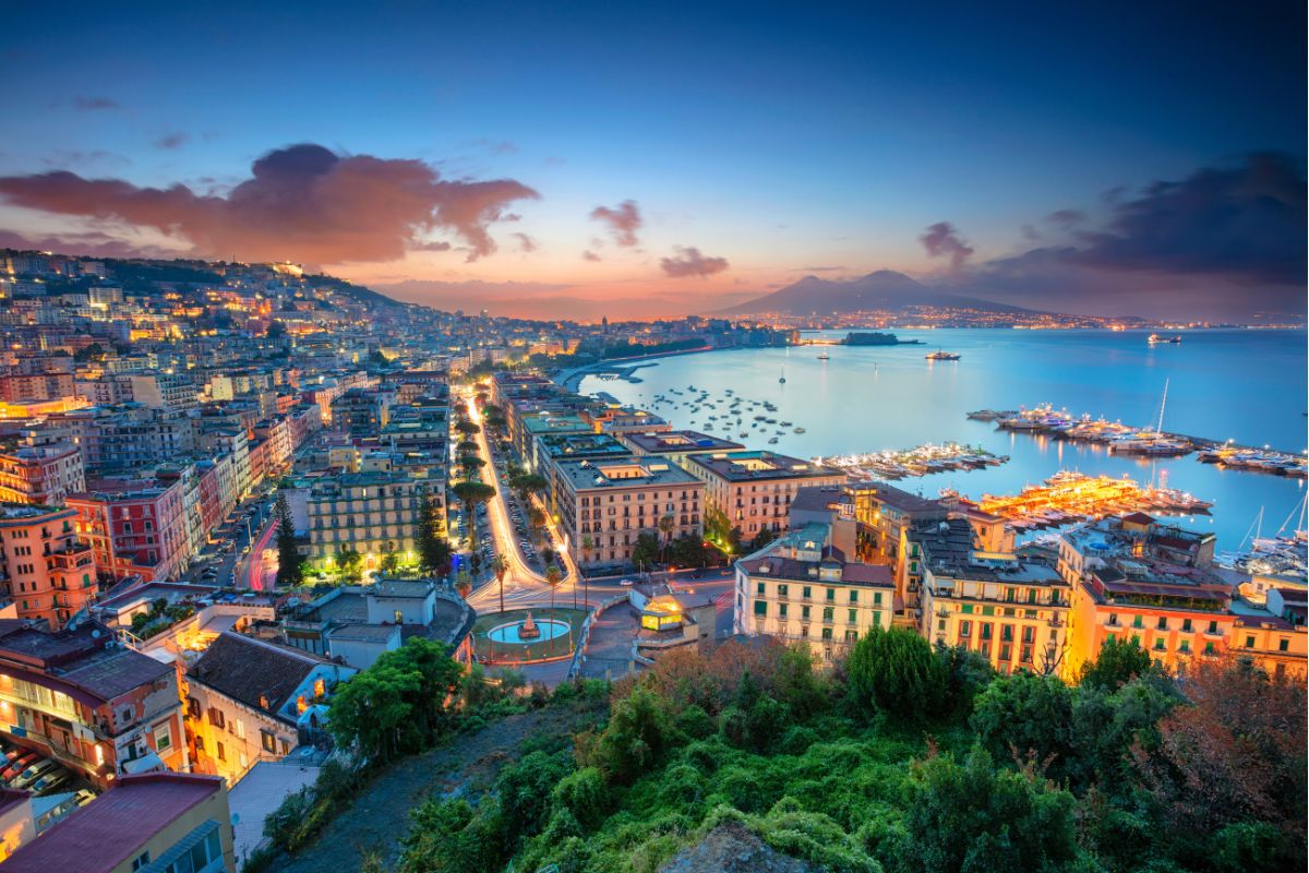 Panorama de Nápoles ao anoitecer com baia ao fundo