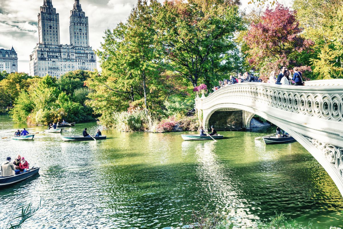 Pessoas passeando em barquinhos em lago do Central Park