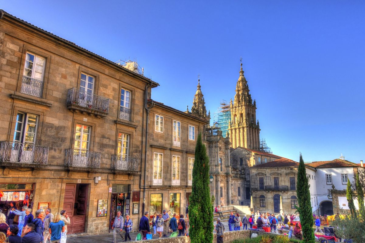 Turistas caminhando em rua comercial de Santiago de Compostela