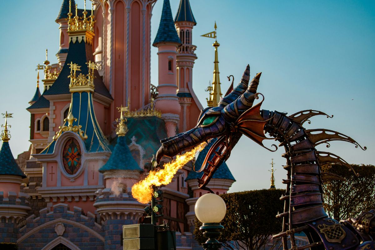 Dragão cuspindo fogo em frente ao castelo da Bela Adormecida