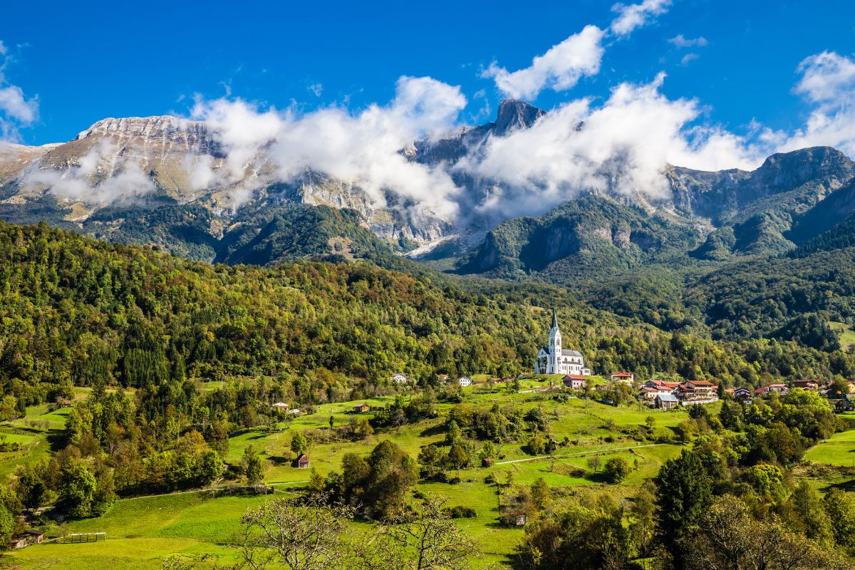 Vila de Drežnica, Eslovênia, vista ao longe em meio às montanhas